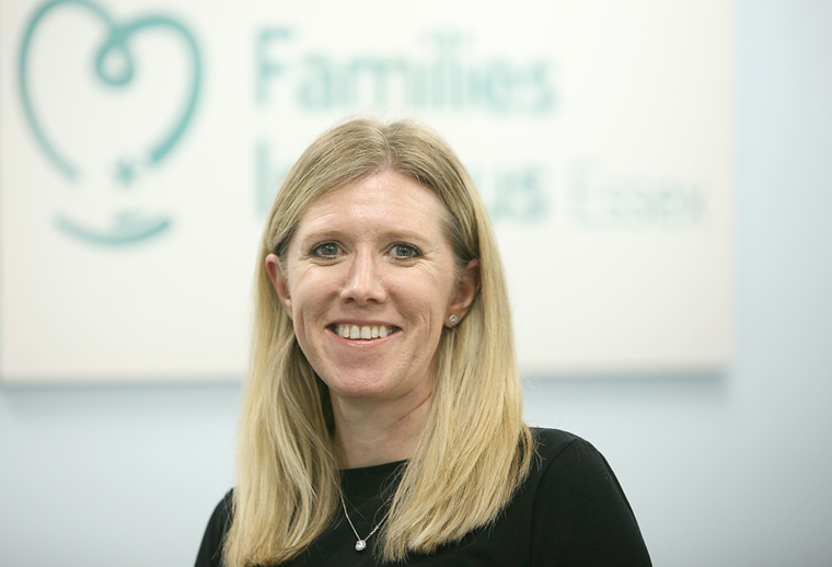 Wendy, a Family Support Adviser is sat in front of our banner